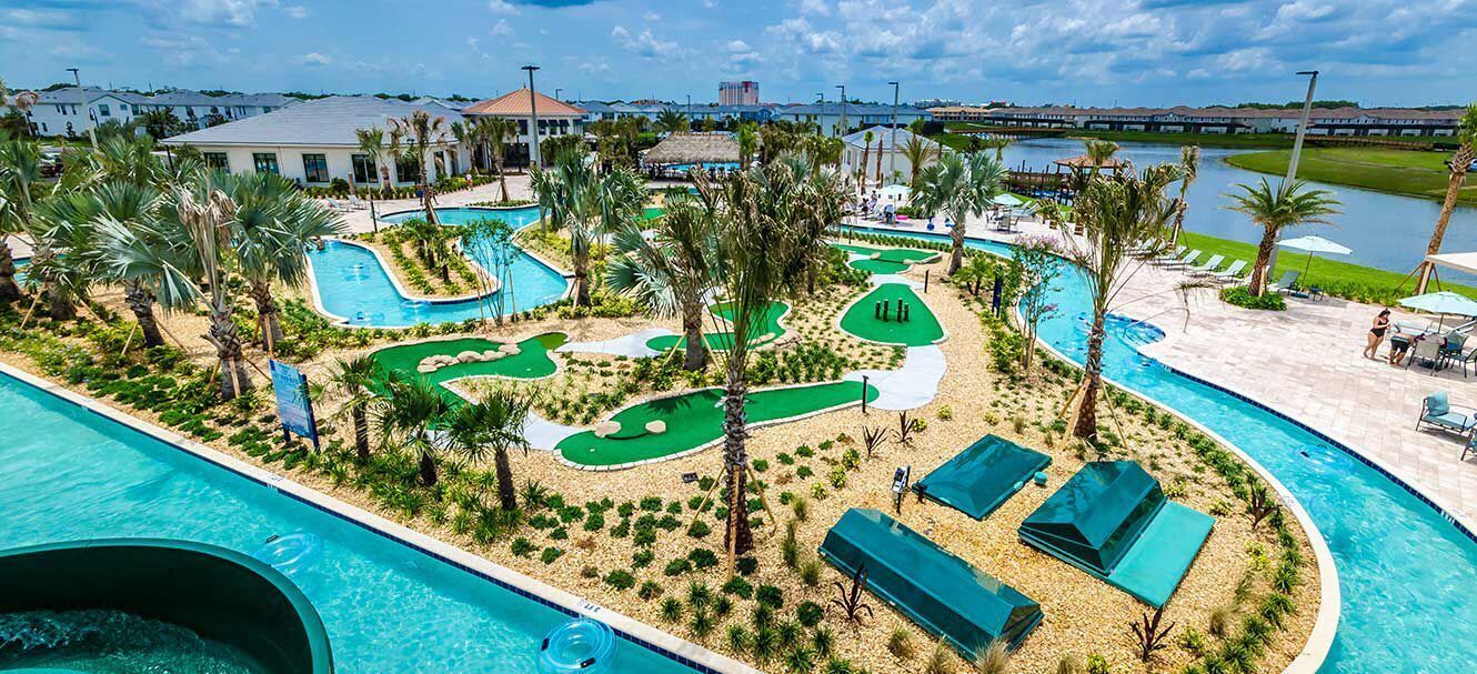 A resort with a swimming pool, a golf course, and a view of the surrounding area.