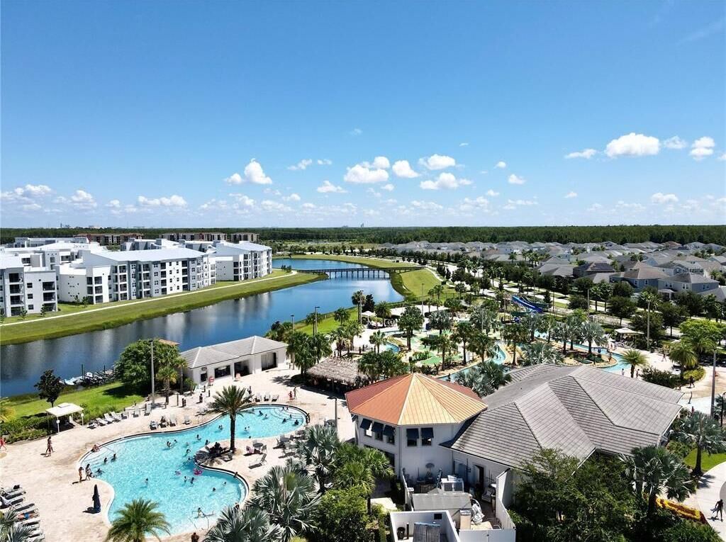 Un complejo turístico con múltiples piscinas, un río y una combinación de arquitectura moderna y tradicional.