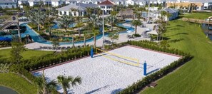 Vista aérea de um resort com uma extensa praia de areia, área de piscina com escorregador e vegetação ao redor.