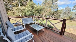 Una terrazza con posti a sedere all'aperto, compresi due sedie e un tavolino.