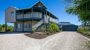 A two-story building with a balcony, a driveway, and a garage.