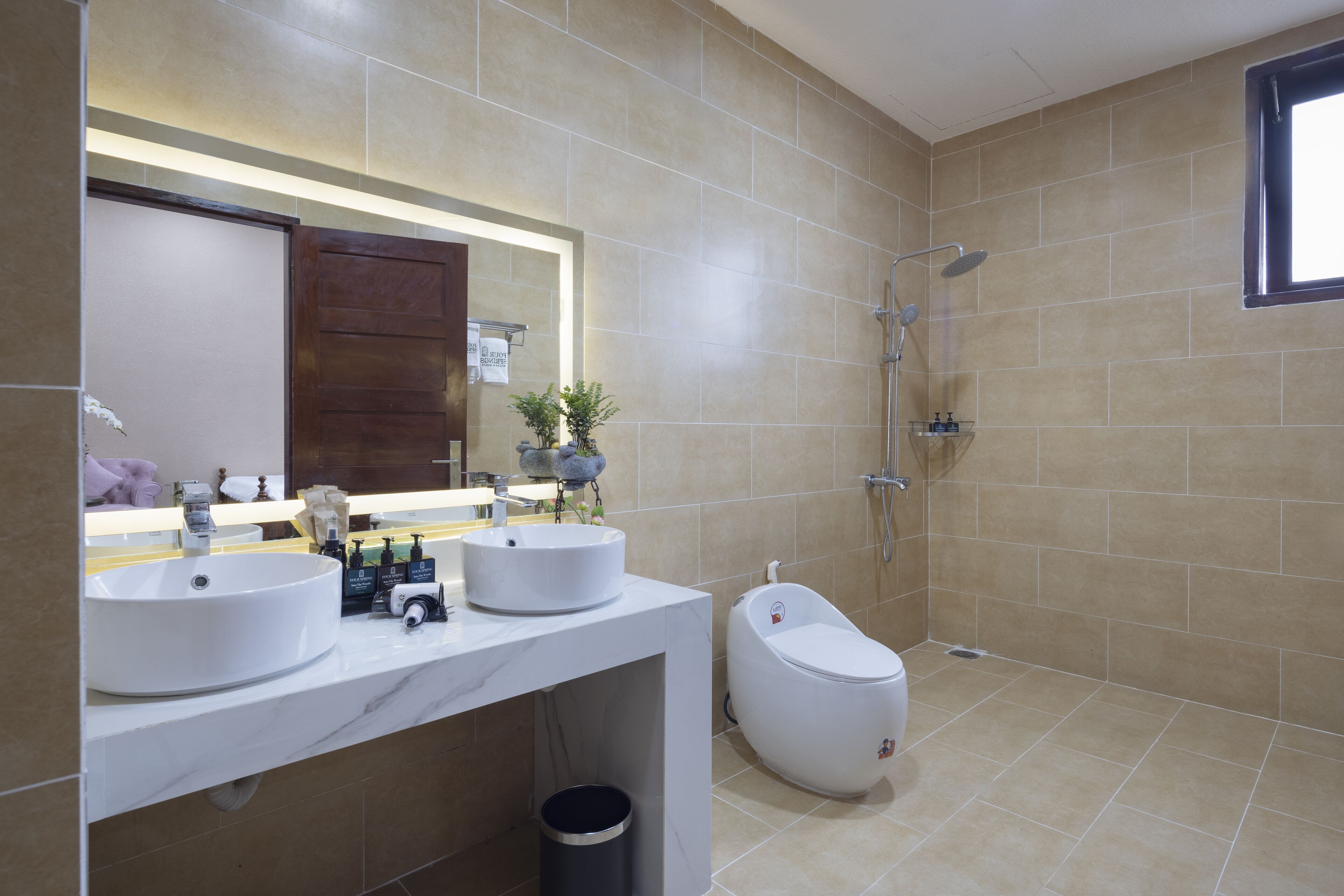 Un baño moderno con dos lavamanos, un inodoro y una ducha.