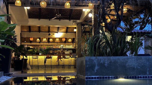 A bar area with seating and a poolside view. - Babel Boutique Hotel (Siem Reap)