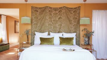 A neatly arranged bedroom with a large bed, two bedside tables, and a hanging light fixture.