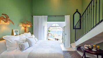 A bedroom with a bed, a table with breakfast items, a staircase, and a view of the outdoors.