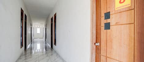 A hallway with a wooden door marked with the number 8, leading to a room.