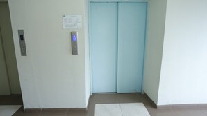 An elevator with a digital display, a door with a light blue color, and a floor plan sign on the wall.