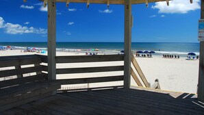 Un refugio de madera en la playa con vistas a la playa y al océano.