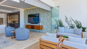 Un salon moderne avec un grand téléviseur à écran plat, un canapé et une table basse.