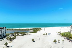 Une vue sur la plage, avec un ciel dégagé, une plage de sable et une étendue d’eau.