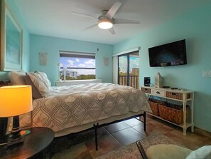 Une chambre avec un lit, un bureau, une télévision et une fenêtre donnant sur un beau paysage.