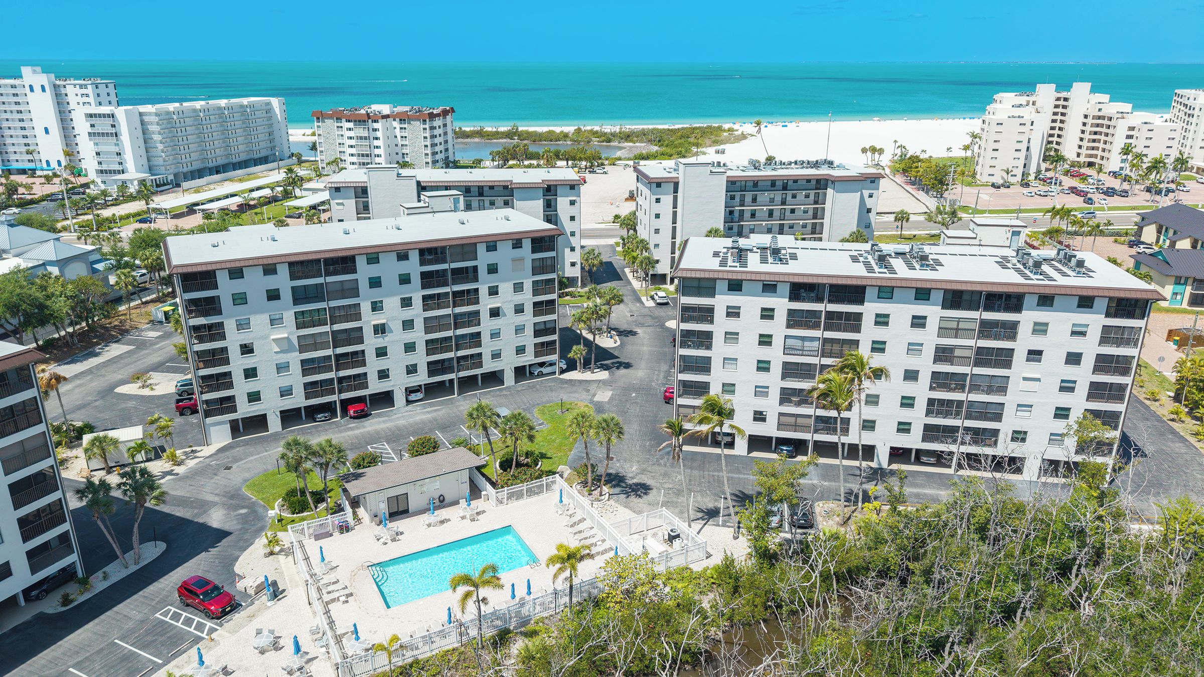 Un hôtel de grande hauteur, avec de nombreux étages, une piscine sur le toit et une vue sur la plage.