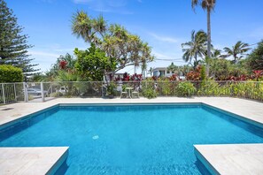 Relax by the pool surrounded by lush tropical vegetation and a serene atmosphere.