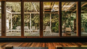 A room with large windows, wooden flooring, and metal chairs. - The Amalfi 20 bedrooms, exclusive use (Hepburn Springs)
