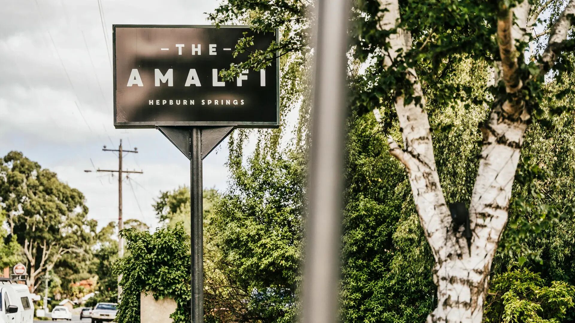 Un panneau indiquant un lieu, avec les inscriptions « THE AMALFI » et « HEPBURN SPRINGS ».
