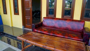Un banco de madera con asiento y respaldo acolchados, sobre un suelo de baldosas con diseño de mármol.