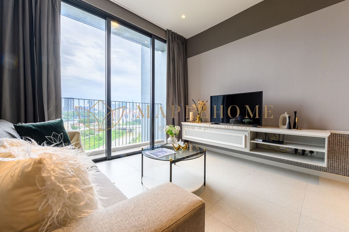 A modern living room with a sofa, a glass coffee table, and a flat-screen TV on a white entertainment unit.