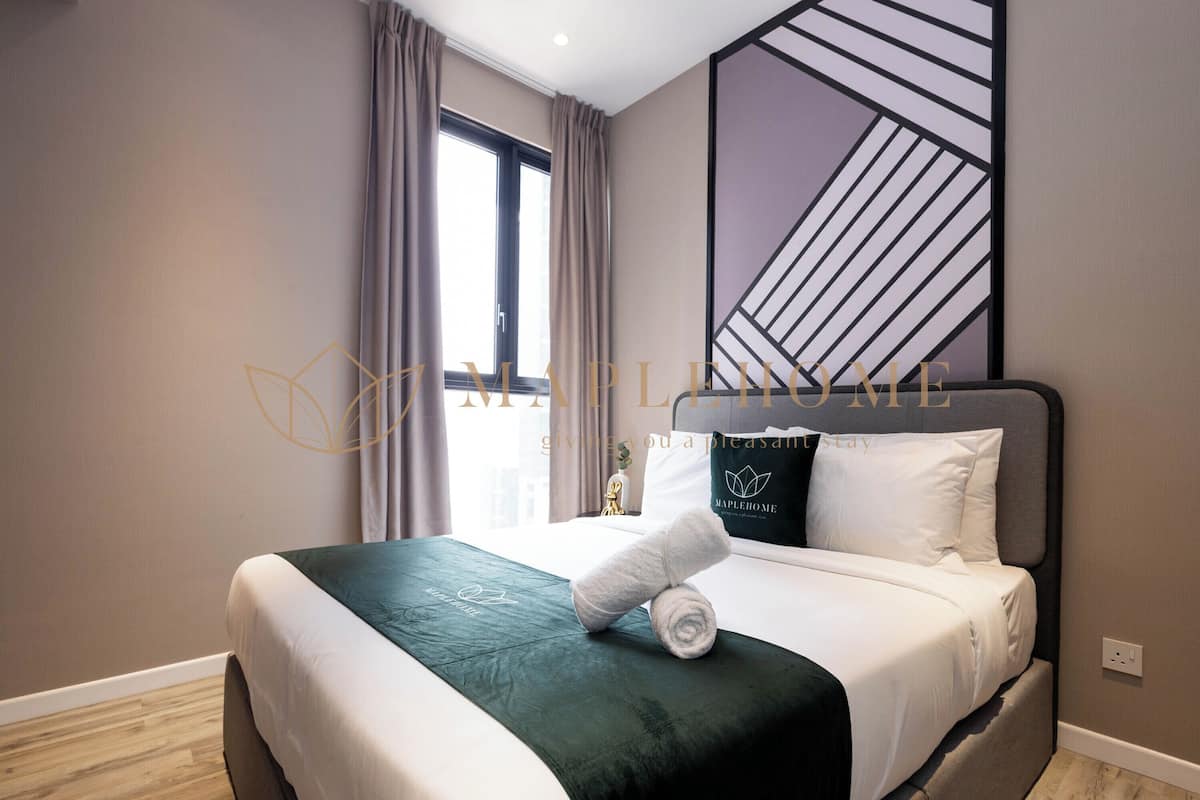 A modern hotel room with a large bed, a decorative headboard, and a view of the city through the window.