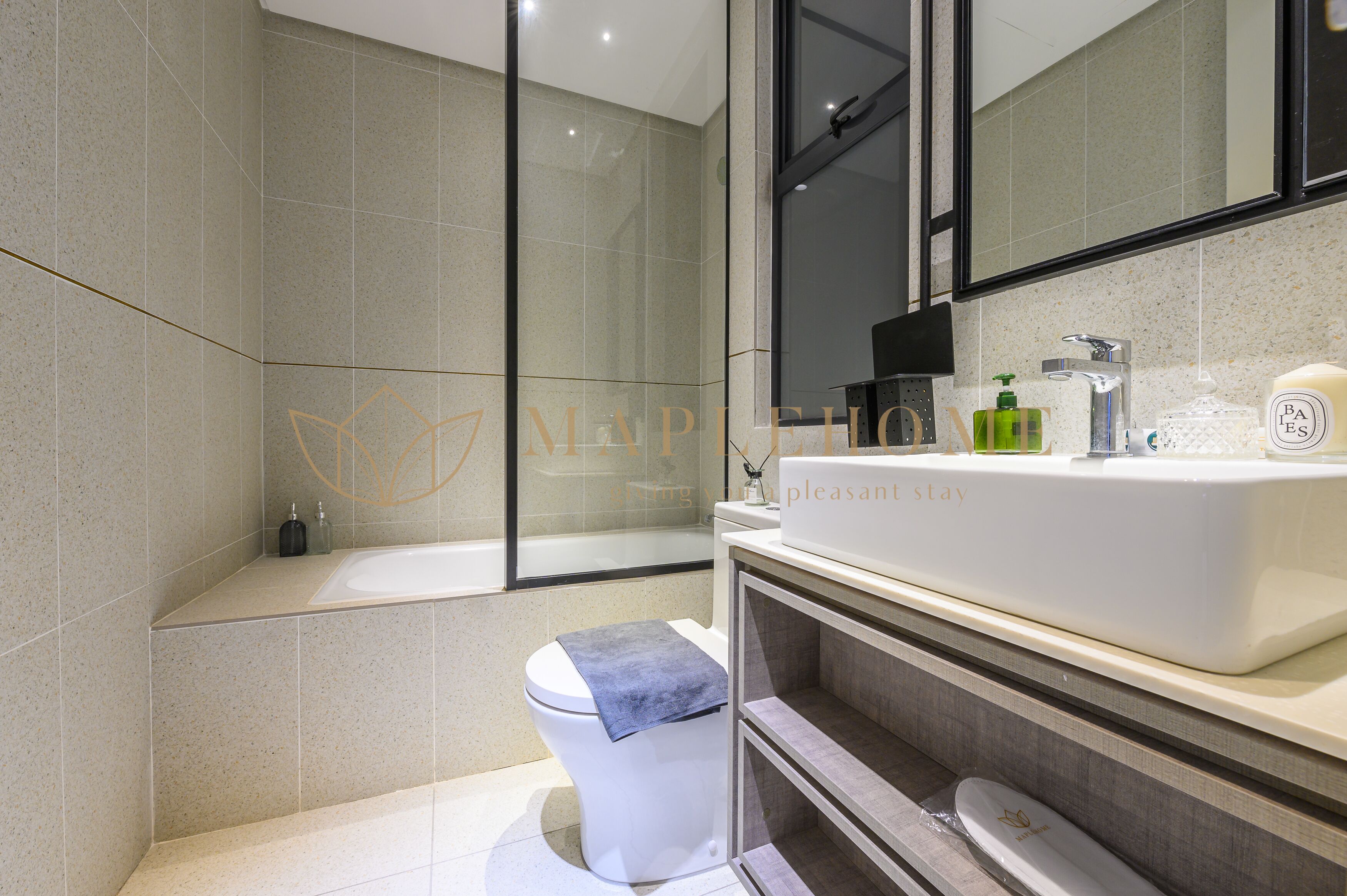 Een moderne badkamer met een bad, toilet en wastafel.