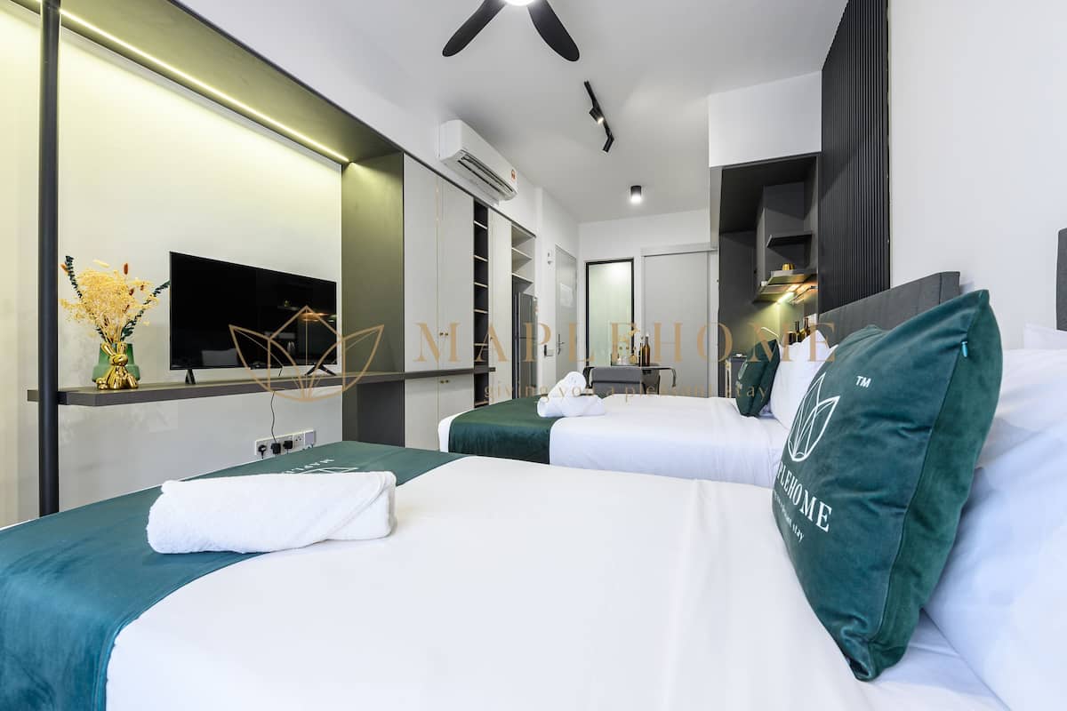 A hotel room with two beds, a flat-screen TV, a minibar, and a large mirror.