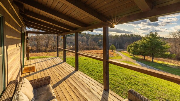 A wooden deck with a view of a rural landscape.