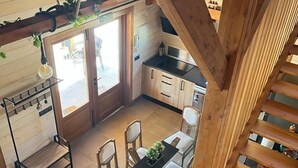 Un interno in legno con zona pranzo, cucina e scala.