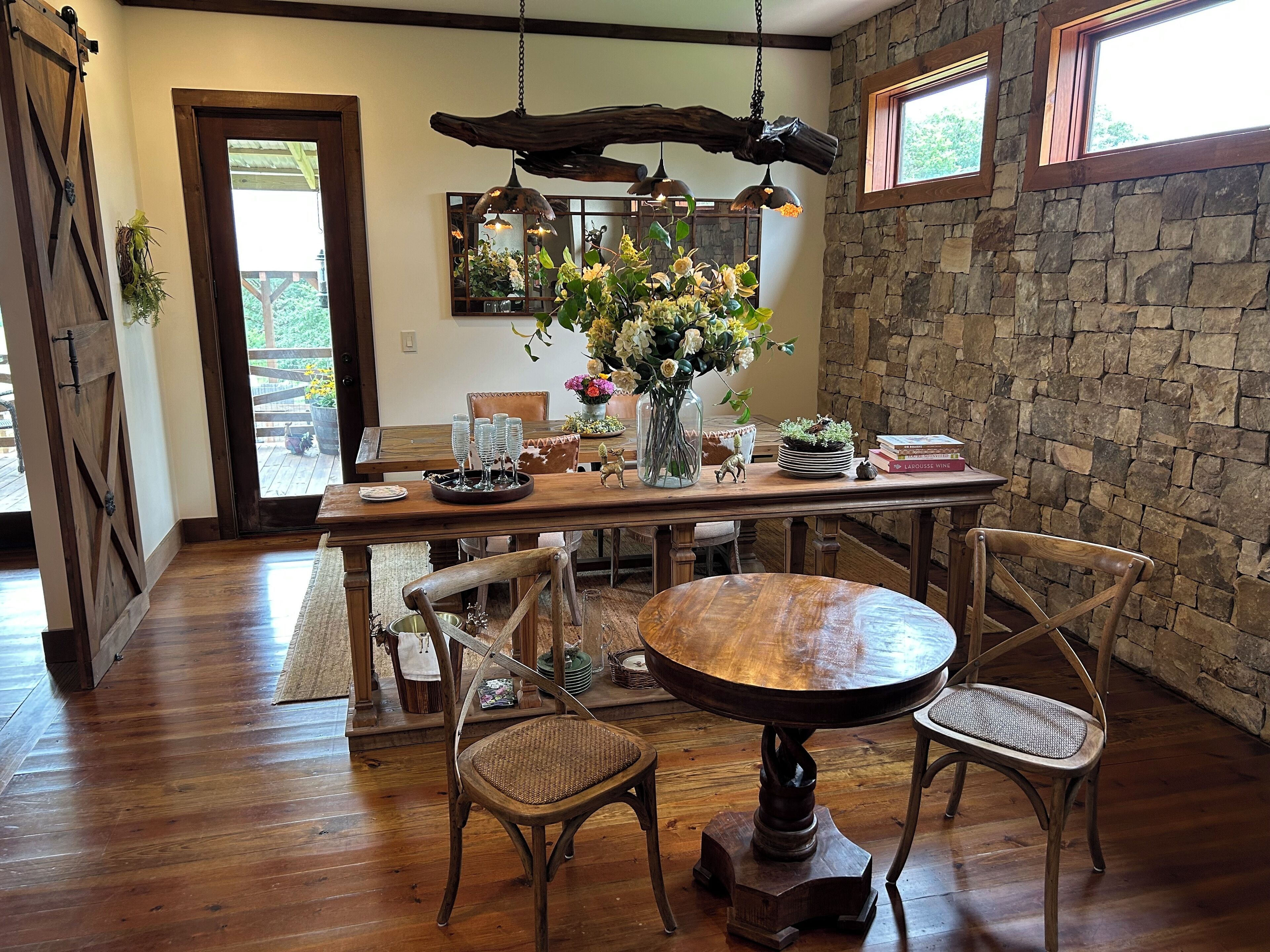 A dining area with a wooden table, chairs, and a hanging light fixture.
