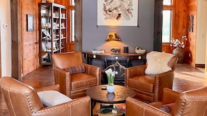 A cozy, wood-paneled room with leather armchairs, a coffee table, and a fireplace. - The Dogwood Inn (Blue Ridge)