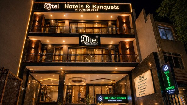A hotel with a two-story facade, a sign for 'The Cozy Dinner Restaurant & Cafe,' and a contact number. - Qotel Comfort Chattarpur- Near Chattarpur Metro (New Delhi)