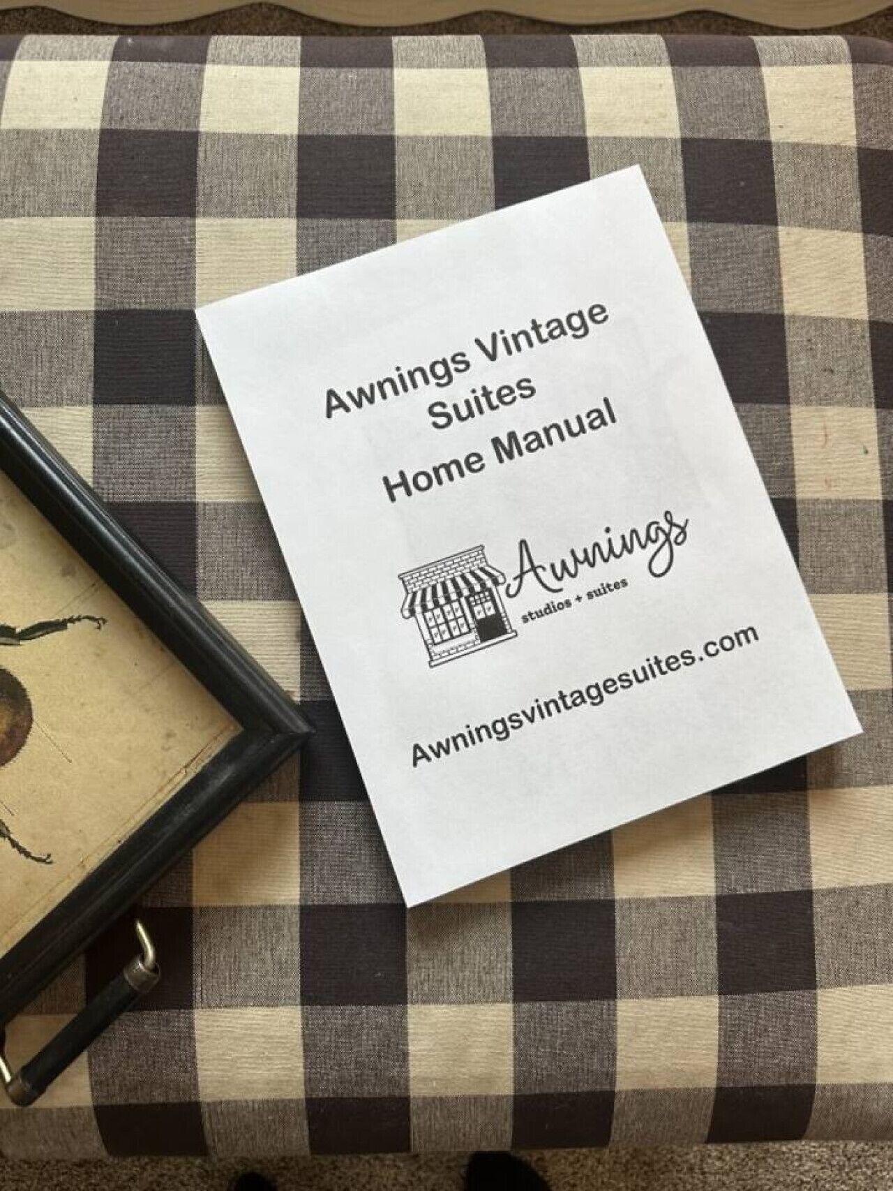 Un folleto blanco con el título 'Manual del Hogar Awnings Vintage Suites', una dirección web y un logotipo.