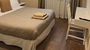 Een hotelkamer met een bed, een bureau, een stoel en een televisie.