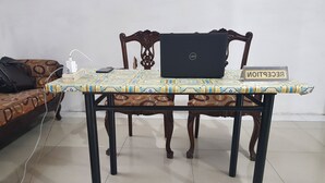 A laptop on a table with a patterned tablecloth, a sign reading "RECEPTION," and a power strip with cables. - Hotel O Cempaka Syariah (Medan)