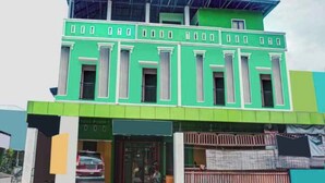 A two-story building with a green facade and a flat roof. - Hotel O Nur Homestay Syariah (Makassar)