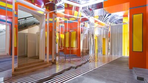 Un intérieur aux couleurs vives, avec un escalier et une cloison en verre.