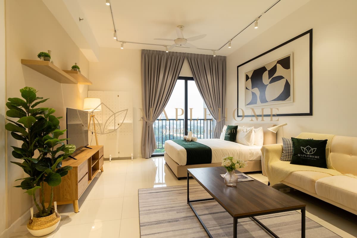 Una sala moderna con cama, sofá, mesa de centro y un ventanal con cortinas. Se ven estantes con plantas y un ventilador de techo.