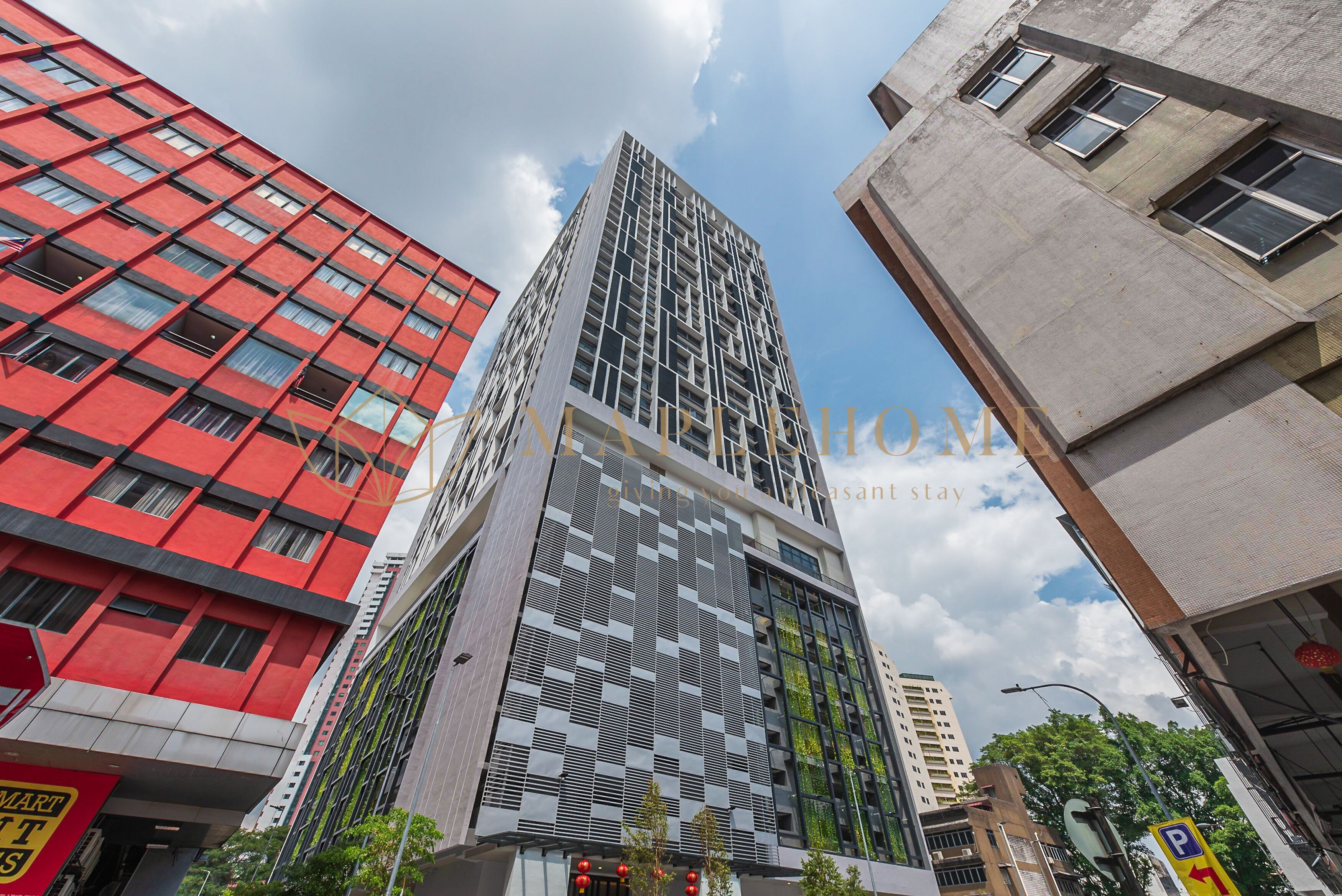 Un edificio moderno de gran altura con fachada a cuadros, rodeado de otros edificios.