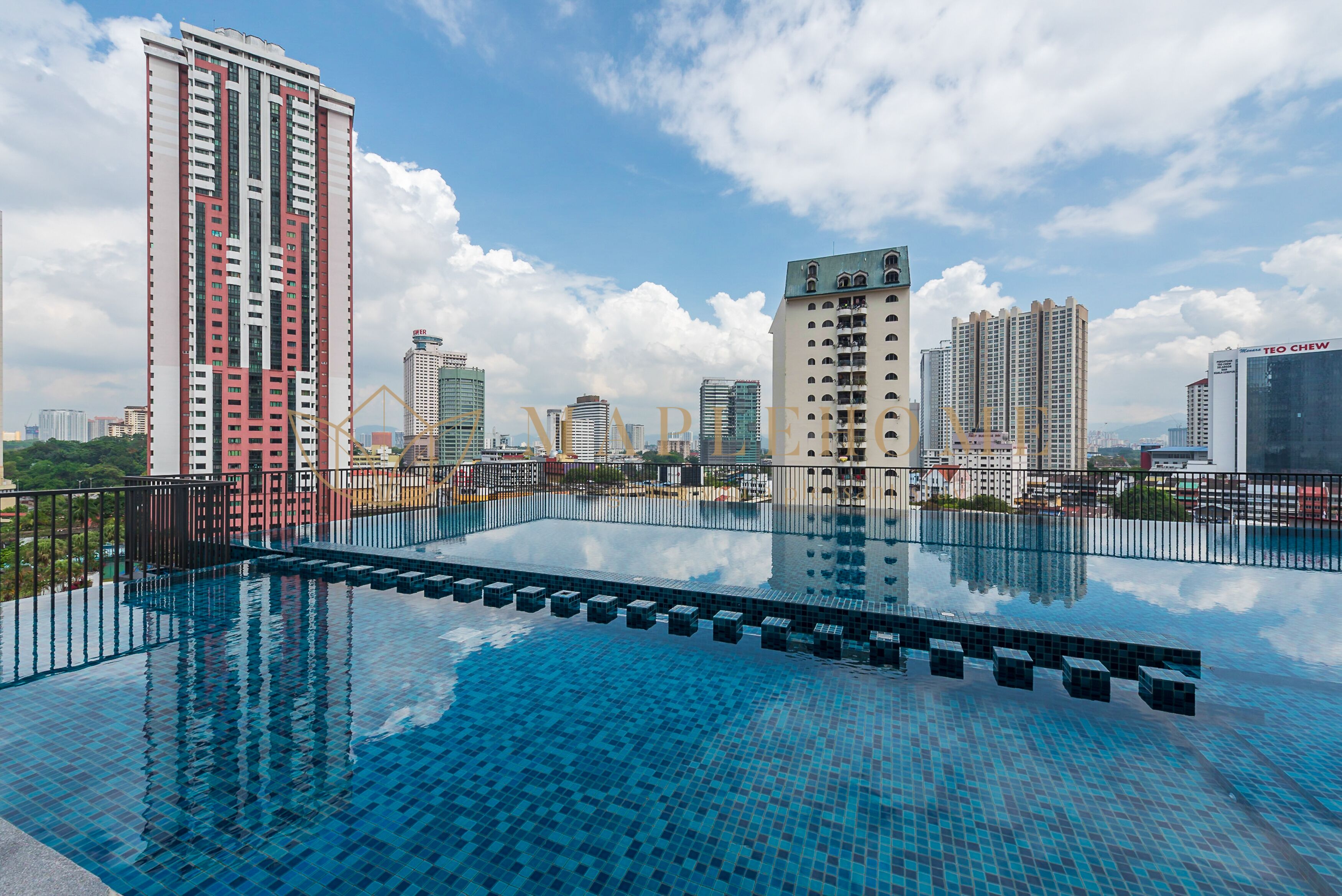A rooftop infinity pool with a cityscape view, surrounded by high-rise buildings.