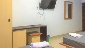 A hotel room with a bed, a desk, a television mounted on the wall, and a mirror. - OYO 93169 Bnb Homestay  (Makassar)