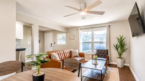 Un salon comprenant un canapé, un fauteuil, une table basse et un ventilateur de plafond.