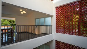 Un interior de varios niveles con escalera, zona de comedor y vistas al exterior.