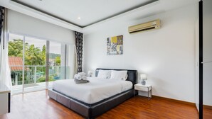 A modern bedroom with a large bed, a nightstand, an air conditioning unit, and a view through a glass door. - Trixie Town House 2 With Private Pool (Rawai)