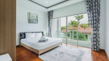 Een slaapkamer met een groot bed, uitzicht op groen en gebouwen, en een modern design.