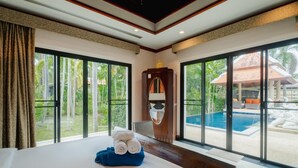 Une chambre d’hôtel avec un grand lit, un miroir et une vue sur une piscine.