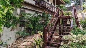 Ein zweistöckiges Haus mit einer Holztreppe und einem Balkon.