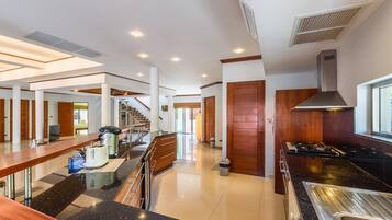 Cozinha moderna com ilha central, eletrodomésticos de aço inoxidável e uma janela ampla que oferece iluminação natural.