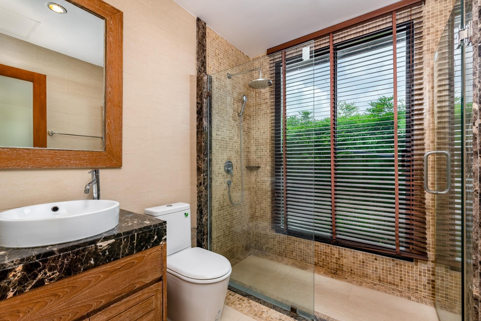 Ein Badezimmer mit Marmorwaschbecken, Toilette und Dusche.
