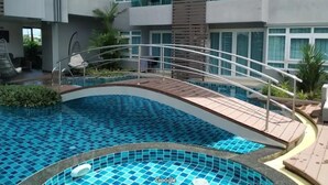 Ett modernt hotell med en swimmingpool, utomhusplats och en byggnad i flera våningar med balkonger.