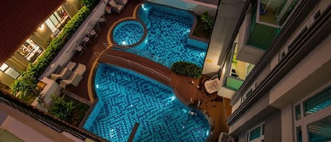 A rooftop swimming pool with multiple sections and a deck area.