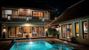 A two-story building with a swimming pool in the foreground.