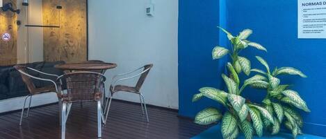 Un'area patio con sedie in vimini, un tavolino rotondo e una pianta in vaso.
